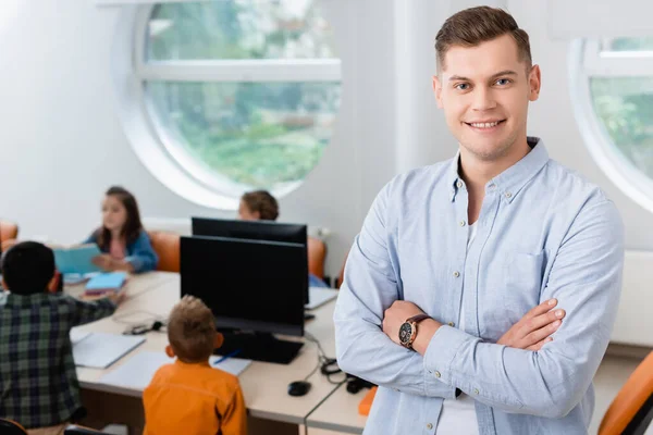 Selective focus of teacher looking at camera near schoolkids in stem school — Stock Photo