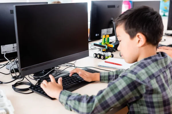 Foco seletivo de estudante asiático usando o computador na escola tronco — Fotografia de Stock