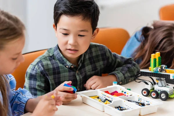 Concentration sélective des élèves multiethniques avec robot de modélisation de blocs de construction dans l'école de la tige — Photo de stock