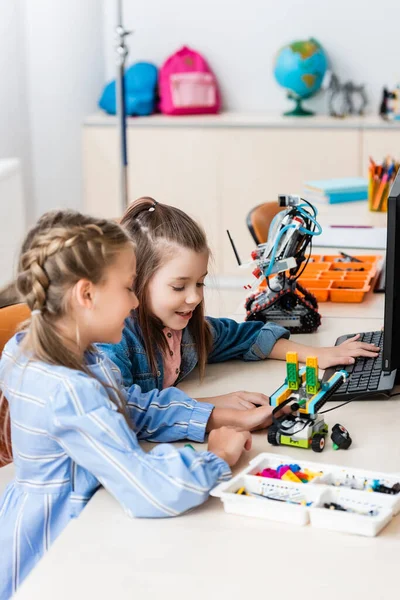 Selective focus of schoolgirls modeling robot from building blocks in stem school — Stock Photo