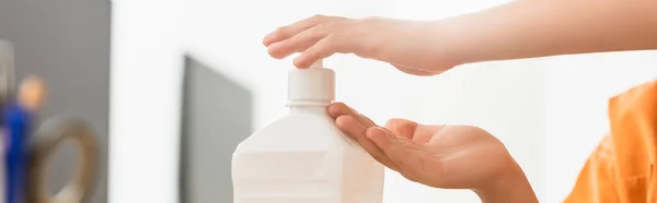 Horizontal image of boy using hand sanitizer in classroom — Stock Photo