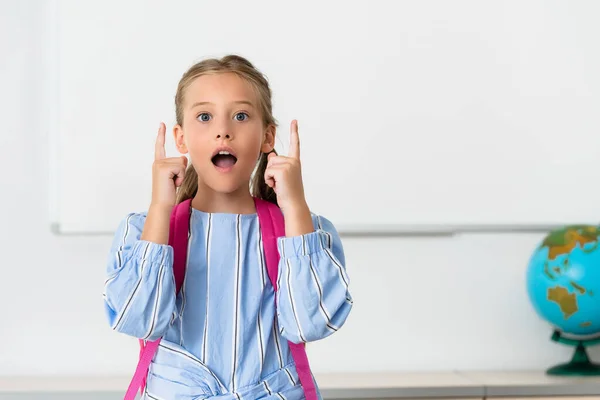 Écolière excitée ayant idée dans la salle de classe de l'école souche — Photo de stock