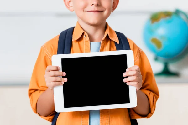 Обрезанный вид школьника, держащего цифровой планшет с пустым экраном — стоковое фото
