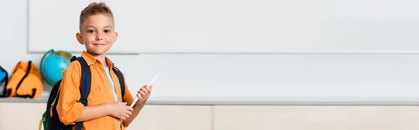 Panoramic shot of schoolboy with backpack and digital tablet in stem school — Stock Photo