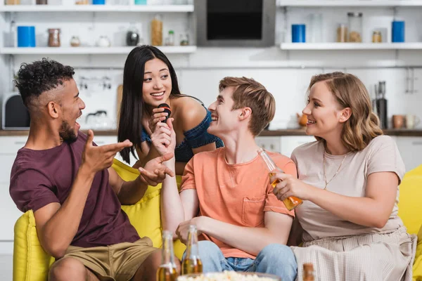 African american man pointing with hands while multiethnic friends singing karaoke — Stock Photo