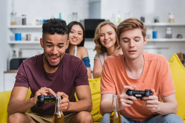 KYIV, UKRAINE - JULY 28, 2020: multicultural friends playing video game during party in kitchen — Stock Photo