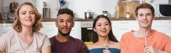 Panoramic orientation of multicultural friends watching tv during party — Stock Photo