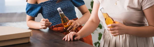 Vista cortada de mulheres jovens segurando cerveja durante a festa, conceito panorâmico — Fotografia de Stock