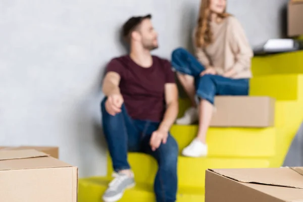 Selective focus of carton boxes near couple on stairs — Stock Photo