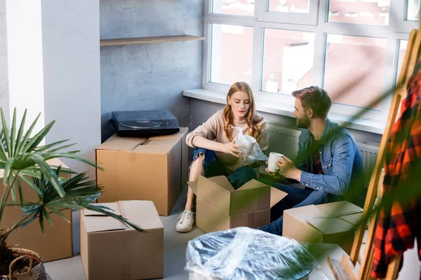 Selektiver Fokus der jungen Frau beim Auspacken der Schachtel mit dem Mann, bewegendes Konzept — Stockfoto