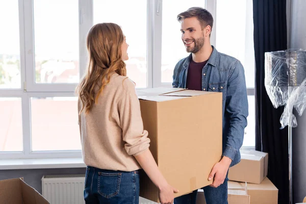 Bearded man and woman holding carton box, moving concept — Stock Photo