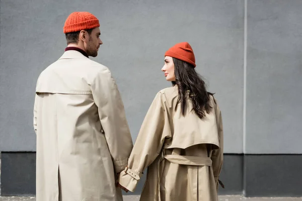 Pareja en traje de otoño tomados de la mano y mirándose unos a otros - foto de stock