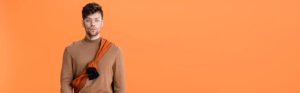 Horizontales Bild des trendigen Mannes im Herbst-Outfit und Brille isoliert auf orange — Stockfoto