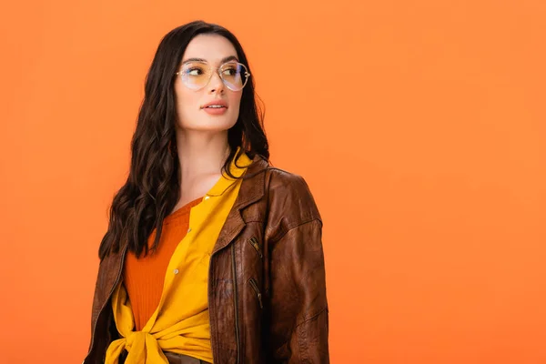 Jeune femme en tenue d'automne et lunettes regardant loin isolé sur orange — Photo de stock