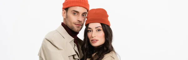Panoramic crop of trendy couple in beanie hats looking at camera isolated on white — Stock Photo
