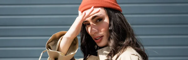 Cultivo panorámico de la mujer con estilo en gorro sombrero escondido de la luz del sol - foto de stock