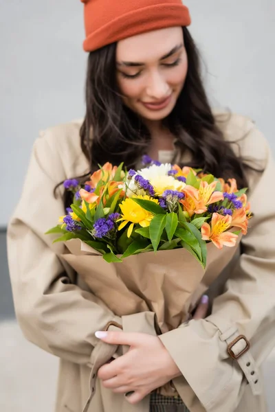 Selektiver Fokus der trendigen Frau beim Betrachten eines Blumenstraußes — Stockfoto