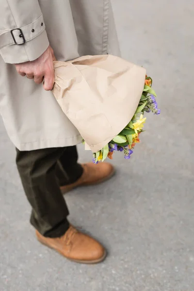 Cropped view of man holding bouquet of flowers outside — Stock Photo