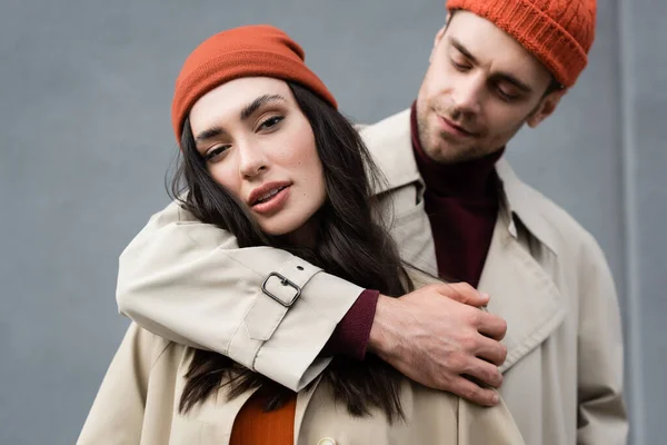 Selective focus of man looking and hugging stylish woman in hat — Stock Photo