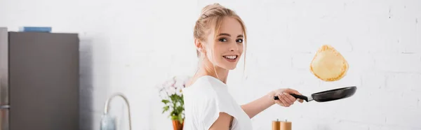 Encabezado del sitio web de la joven mujer rubia preparando panqueques para el desayuno - foto de stock