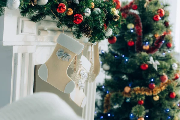 Selective focus of christmas stocking on decorated spruce branch near fireplace — Stock Photo