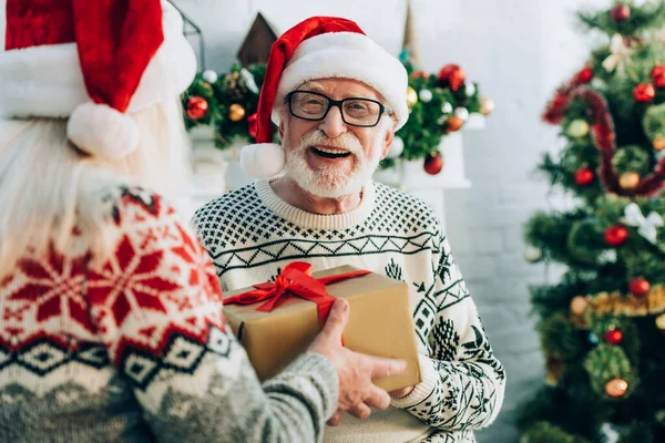 Вибірковий фокус старшої жінки, що представляє подарункову коробку веселому чоловікові — стокове фото