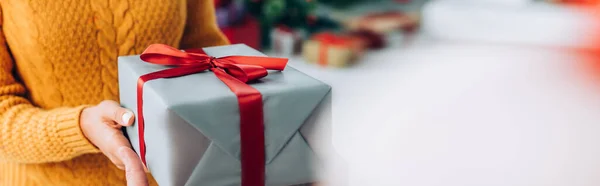 Partial view of woman holding christmas gift box, website header — Stock Photo