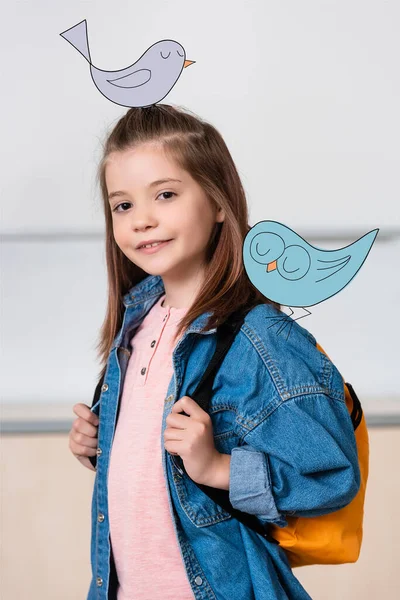 Schoolgirl with backpack looking at camera near birds illustration — Stock Photo