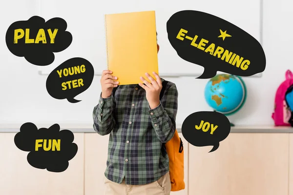 Schoolboy holding book near face and play, youngster and e-learning illustration — Stock Photo