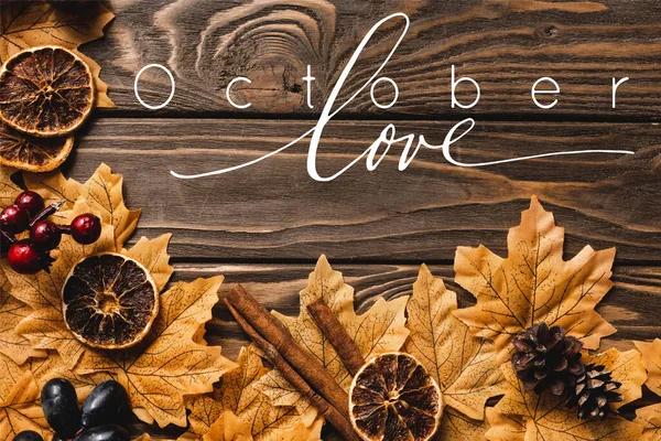 Vue de dessus de la décoration automnale et le feuillage près de Octobre amour lettrage sur fond en bois — Photo de stock