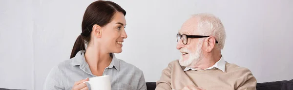 Femme gaie avec tasse de thé parler à heureux père âgé, bannière — Photo de stock