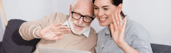 Femme souriante adulte avec un père âgé joyeux agitant les mains à la maison, bannière — Photo de stock