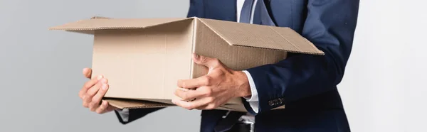 Cropped view of dismissed businessman holding carton box, banner — Stock Photo