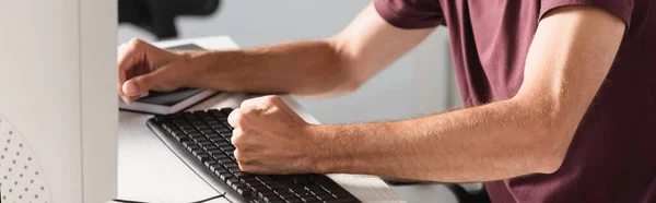 Vue recadrée de l'homme d'affaires stressé battant clavier d'ordinateur dans le bureau, bannière — Photo de stock