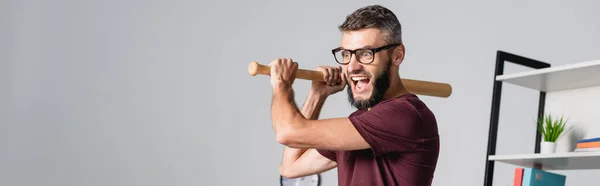 Stressed businessman holding baseball bat while screaming in office, banner — Stock Photo