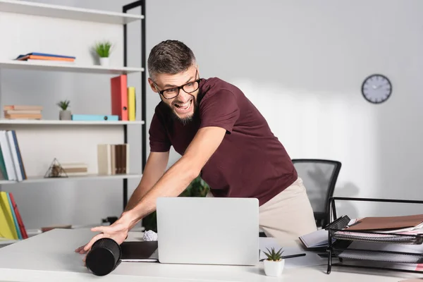 Homme d'affaires stressé jetant ordinateur portable et papeterie de table de bureau — Photo de stock