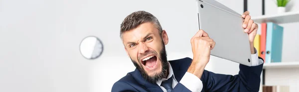 Mad businessman holding laptop in office, banner — Stock Photo