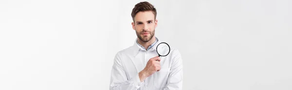 Front view of ophthalmologist in white coat with loupe looking at camera isolated on white, banner — Stock Photo