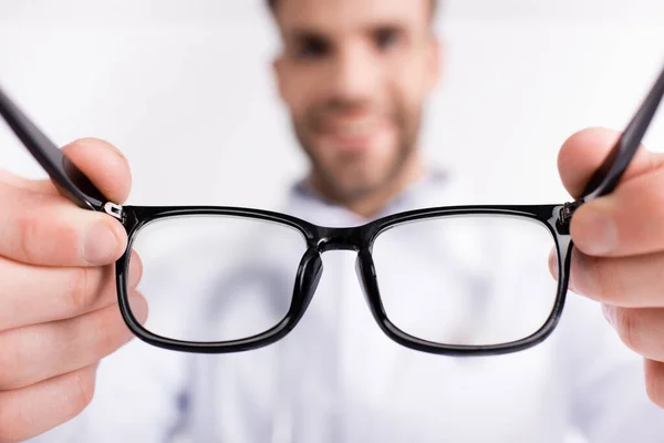 Gafas graduadas con montura negra con médico borroso sobre fondo - foto de stock