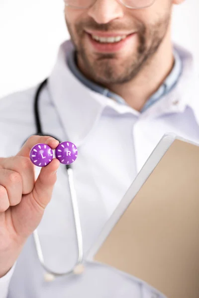 Vue recadrée d'un ophtalmologiste souriant montrant un contenant de lentilles sur fond flou — Photo de stock