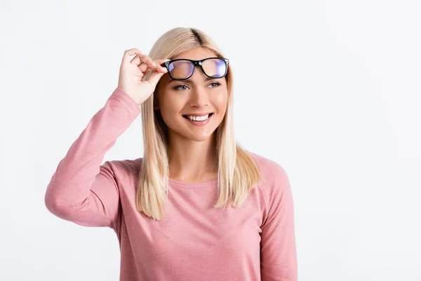 Donna bionda sorridente mentre tiene gli occhiali isolati su grigio — Foto stock