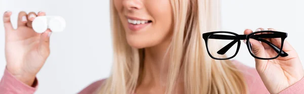 Occhiali in mano di donna sorridente con lenti a contatto su sfondo sfocato isolato su bianco, striscione — Foto stock