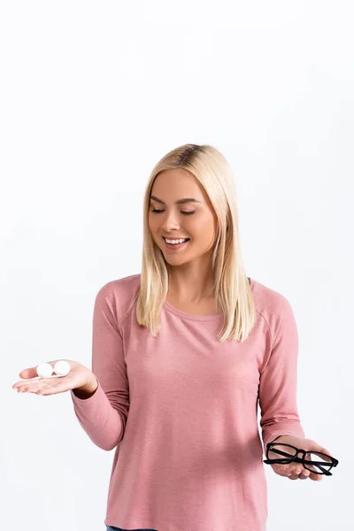 Positive Frau hält Behälter mit Kontaktlinsen und Brille isoliert auf weiß — Stockfoto