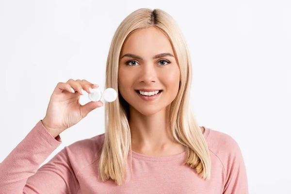 Donna bionda sorridente che tiene il contenitore con lenti a contatto isolate su bianco — Foto stock