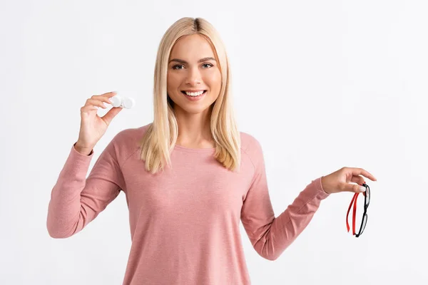 Cheerful woman with contact lenses and eyeglasses looking at camera isolated on white — Stock Photo