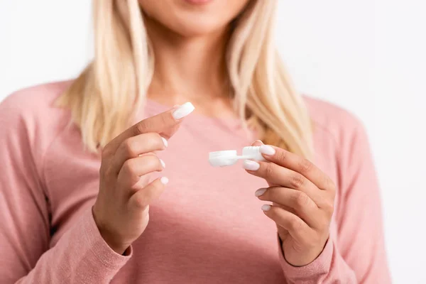 Cropped view of woman holding box and contact lenses on blurred background isolated on white — Stock Photo