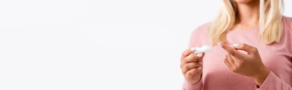 Обрізаний вид молодої жінки, що тримає коробку з контактними лінзами ізольовано на білому фоні, банер — стокове фото