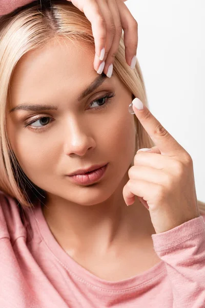 Blonde Frau trägt Kontaktlinse isoliert auf weiß — Stockfoto