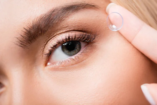 Close up view of woman holding contact lens near eye — Stock Photo