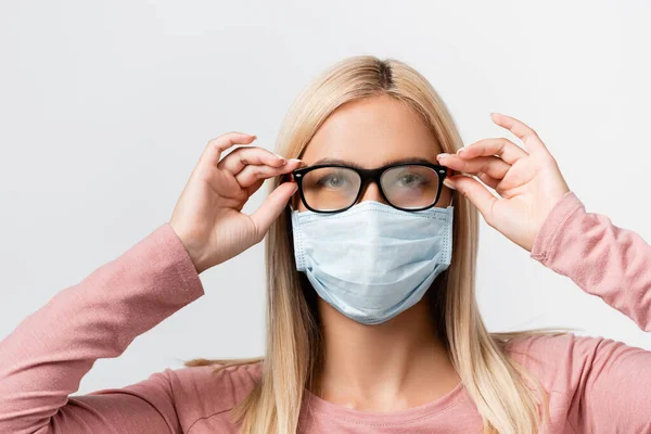 Молода жінка в медичній масці тримає помилкові окуляри ізольовані на сірому — стокове фото